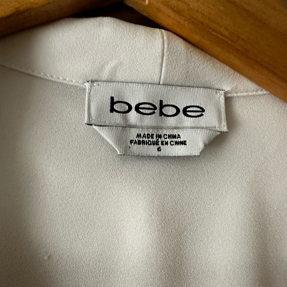 Light white sleeveless jacket with sheer tails.